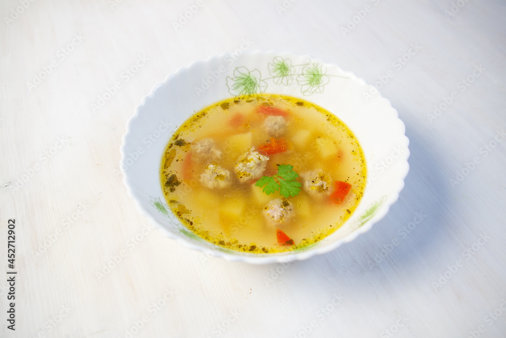 soup with meatballs, potato, spicies in bowl on white background soup with meatballs, potato, spicies in bowl on white background