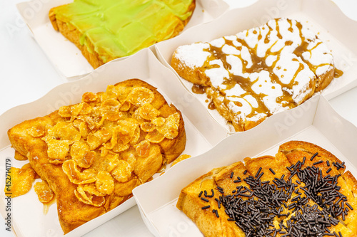 Sliced bread topping with chocolate, icing and hunny, green custard coconut jam and cereal photo