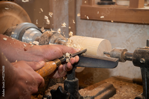 Fotografija Close up of woodworker using a lathe with chips flying