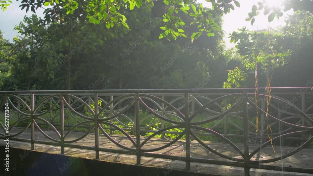 Asian woman in sportswear with face mask jogging over the bridge under warm morning sunlight in the park. Summer exercising among beautiful nature outdoor. Pollution free environment. Asian woman in sportswear with face mask jogging over the bridge under warm morning sunlight in the park. Summer exercising among beautiful nature outdoor. Pollution free environment.