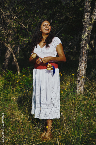 Woman Holding Indigenous Maracas In Forest photo