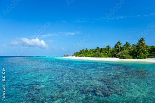 Maldives island with crystal clear sea, coral and blue sky. © nattanapong