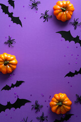Happy Halloween holiday party poster with pumpkins, bats, spider on purple background. Flat lay, top view, overhead.