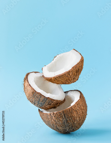 Cracked coconuts on blue background. vertical. copy space