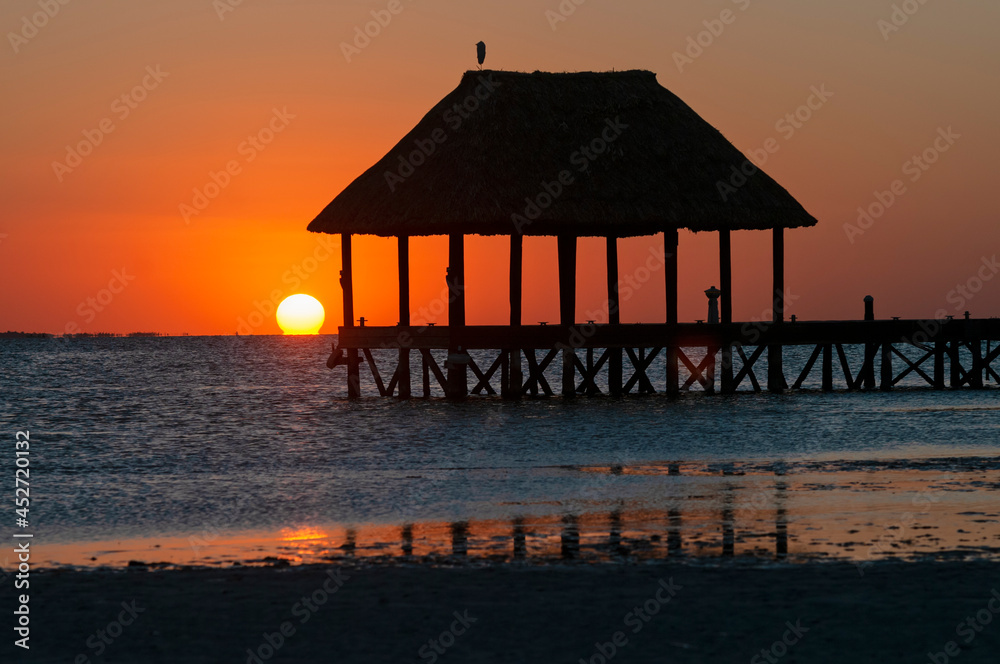 A wooden pier on the sea at sunset on Holbox Island in Mexico
