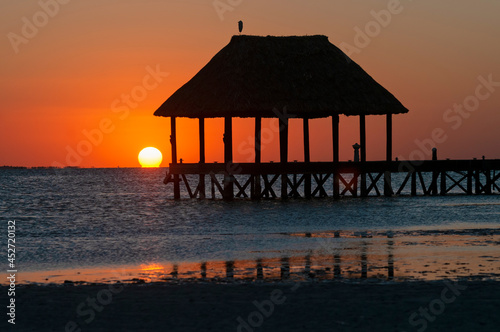 A wooden pier on the sea at sunset on Holbox Island in Mexico