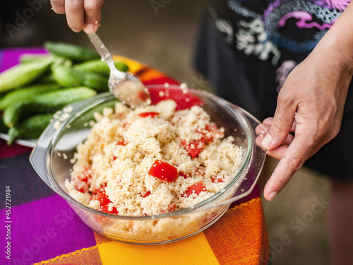 Preparation vegetable salad. Woman preparing food on table at backyard. Making vegetarian food