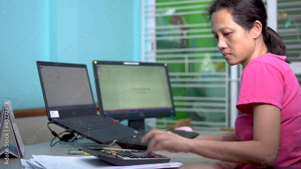 Woman works from home using a laptop computer connecting a keyboard and extending a monitor. Woman works from home using a laptop computer connecting a keyboard and extending a monitor.