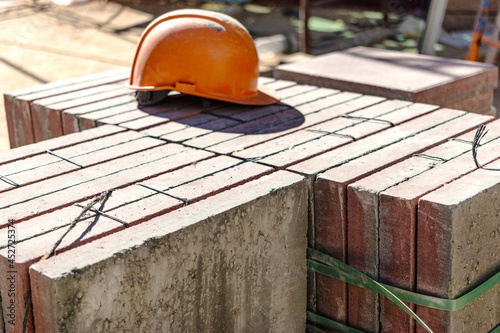 An old work helmet rests on folded paving slabs. Rest break at the construction site. Hard work of a builder.