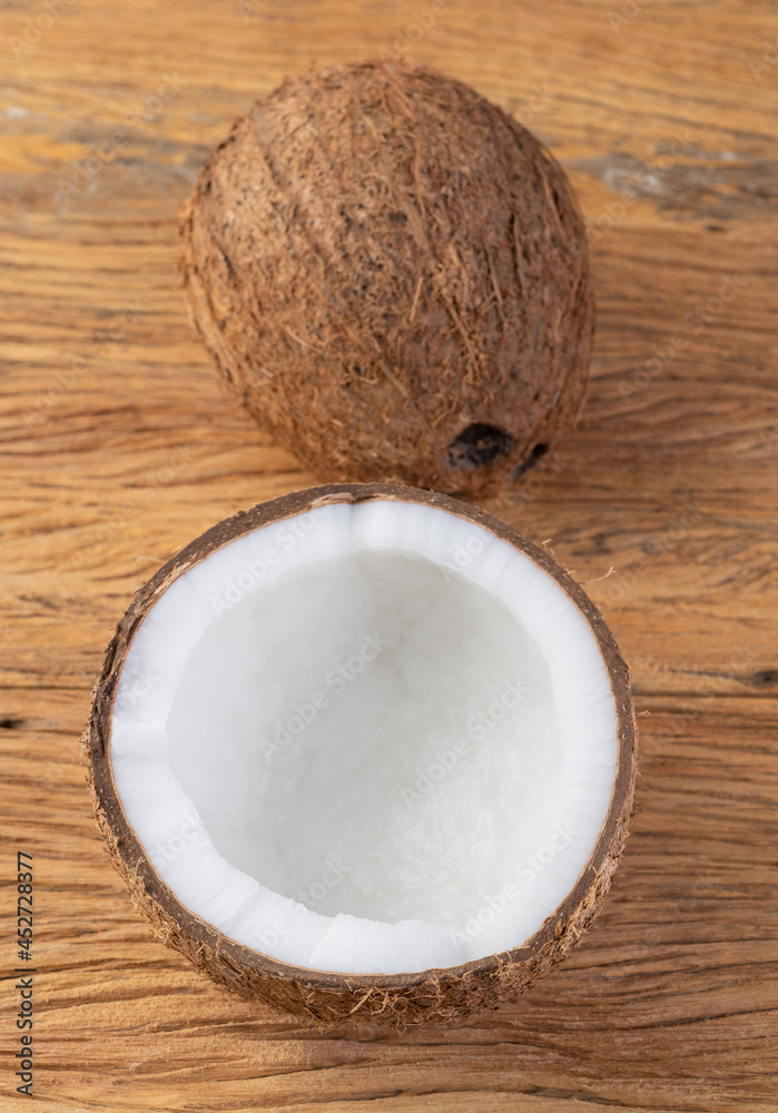 Coconut and cracked half fruit over wooden table Coconut and cracked half fruit over wooden table