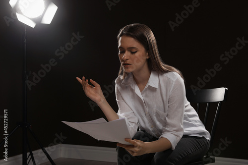 Photo Professional actress reading her script during rehearsal in theatre