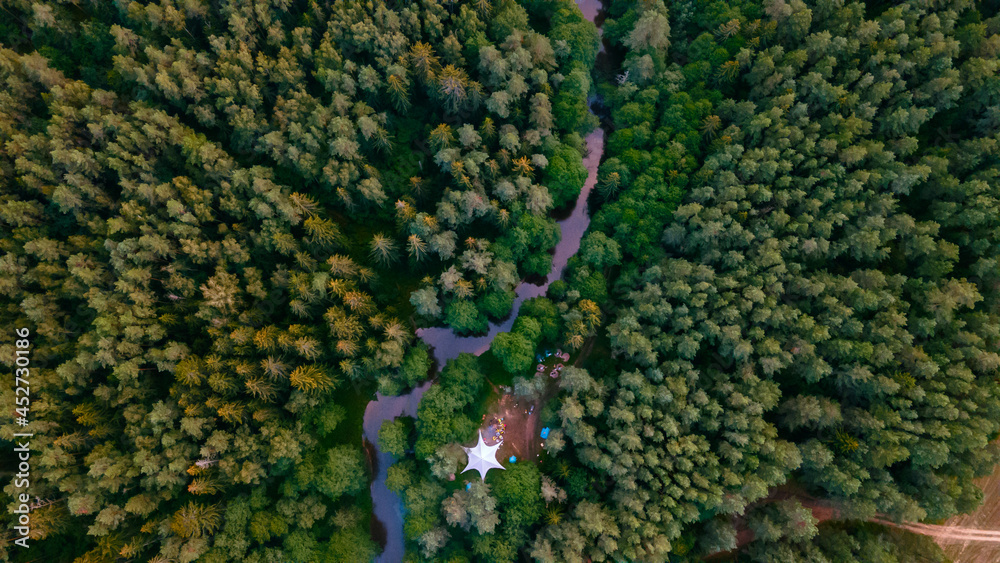 Top view camping in the holidays. Tourist tents in the forest on the river bank. Aerial view. Travel concept. Top view camping in the holidays. Tourist tents in the forest on the river bank. Aerial view. Travel concept.