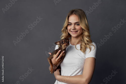 woman in white t-shirt with small purebred dog charm friendship