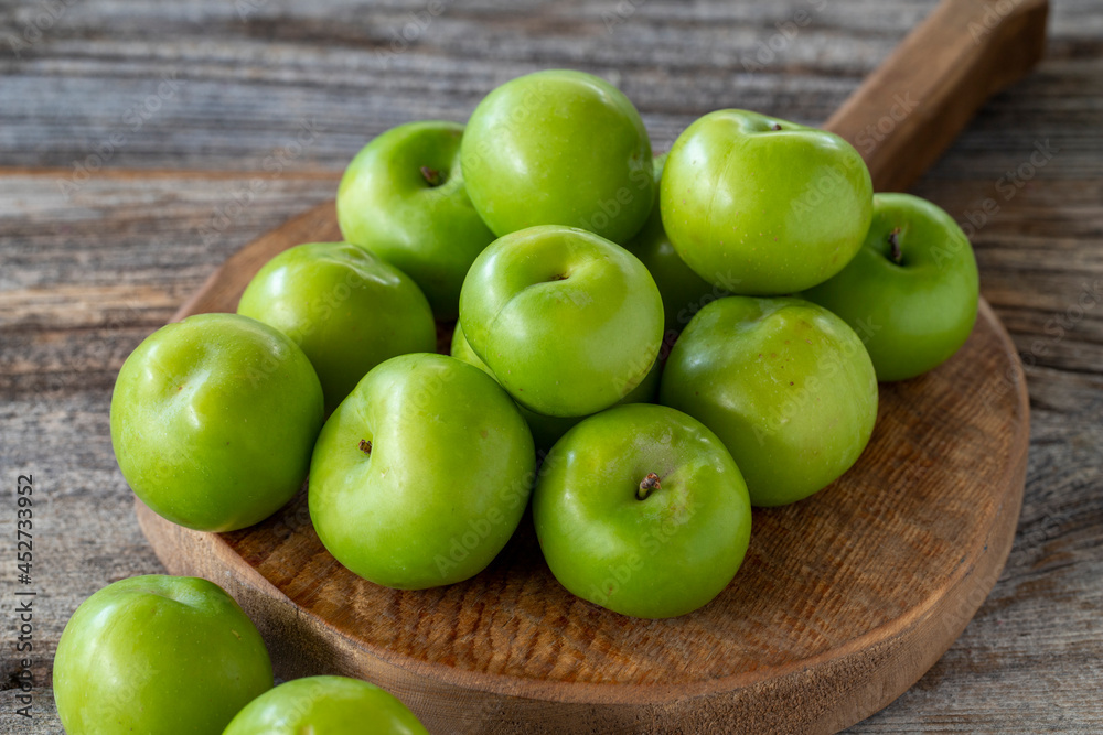 fresh green plums on wood background. Close up fresh green plums on wood background. Close up