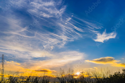 Sunset clouds with sun setting down, Sunbeams Shining through Natural Forest in twilight with sunset , Thailand , Asia