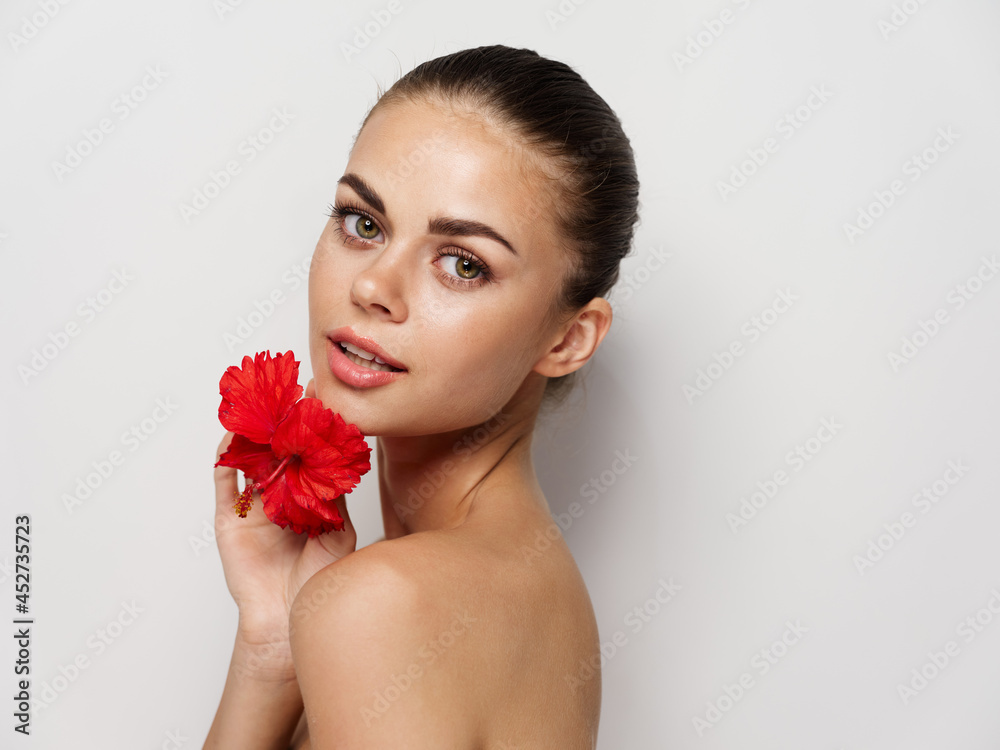 woman with bare shoulders red flower makeup close-up light background woman with bare shoulders red flower makeup close-up light background