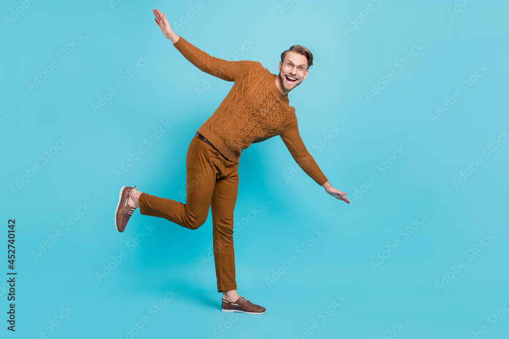 Fototapeta premium Full body photo of charming happy young man dance hands wings smile isolated on blue color background