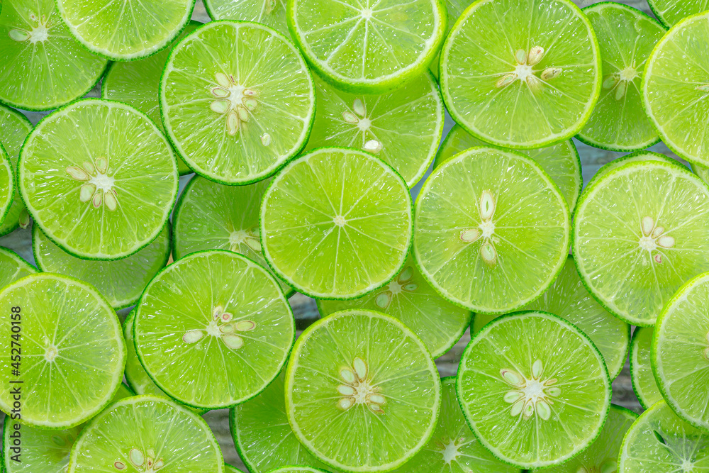 Macro Lime,Lemon and green lime overlapped slices close-up background.