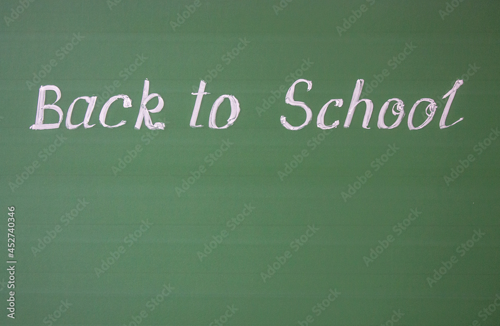 Handwritten inscription: back to school and copy space on a green chalkboard with chalk streaks Handwritten inscription: back to school and copy space on a green chalkboard with chalk streaks
