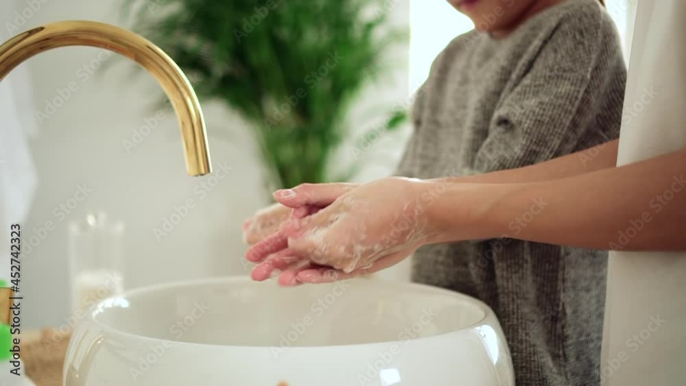 Washing hands with antibacterial soap. Spbd Little kid girl with lady parent rub diligently foamy palms above elegant vessel sink in light bathroom closeup
