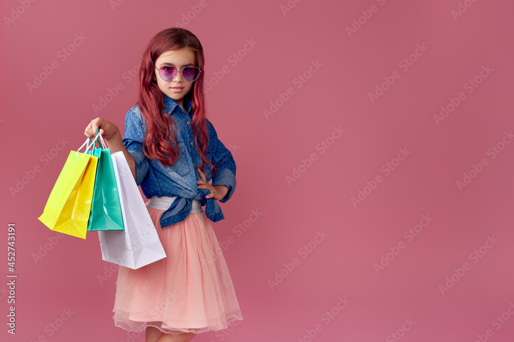 little caucasian child girl holds shopping bags