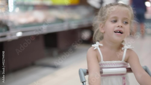 Wallpaper Mural Handheld effect Funny cute child pushing shopping cart in supermarket. Little girl buying with special shopping cart for children Kid grocery shopping. Adorable baby kid with trolley  Torontodigital.ca