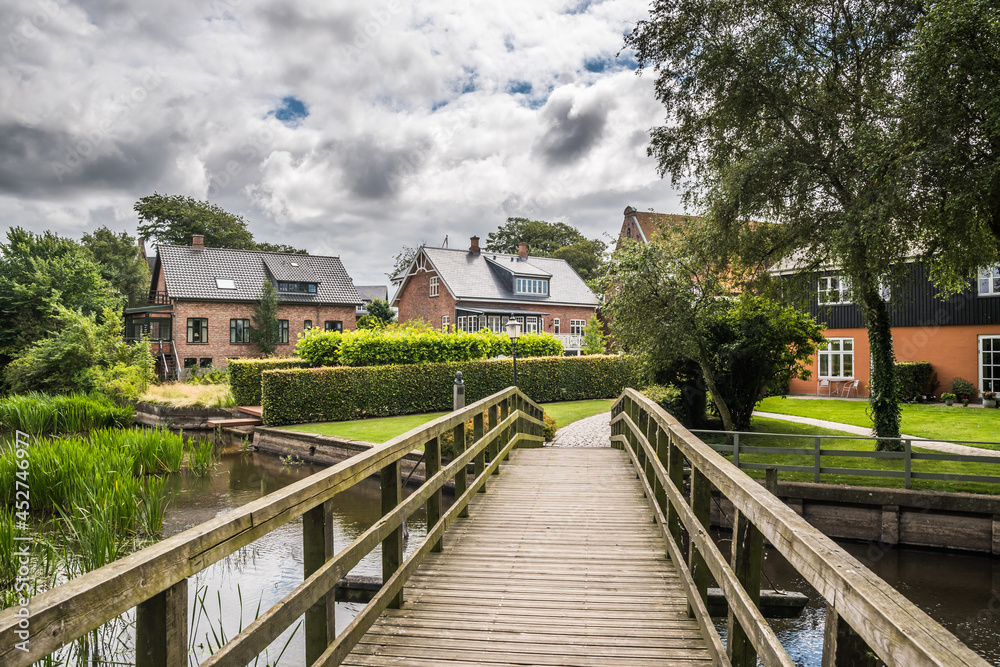 Wooden bridge over a small water canal in a beautiful park in the oldest city of Denmark, Ribe