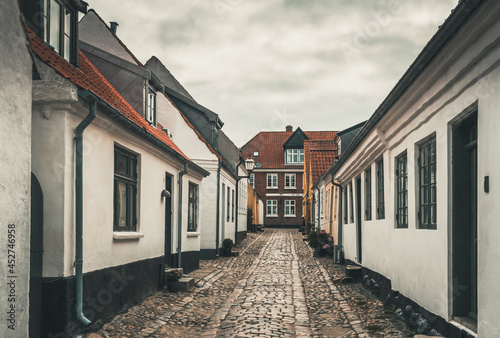 Fototapeta Naklejka Na Ścianę i Meble -  Ribe, Denmark - August 4, 2021: A small cobblestone street in Denmark's oldest city Ribe
