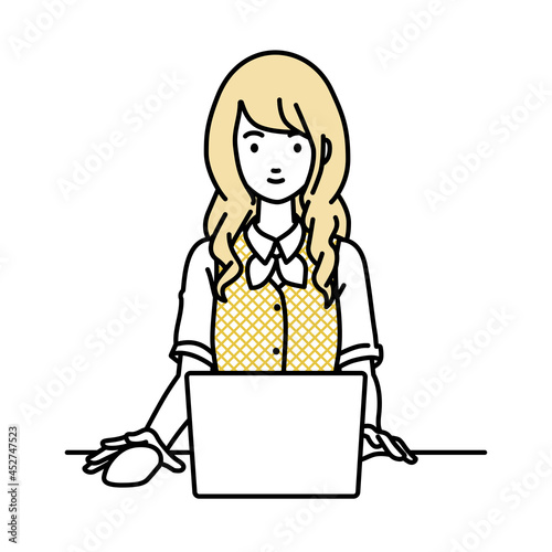 デスクで座ってPCを使っている事務員制服の女性