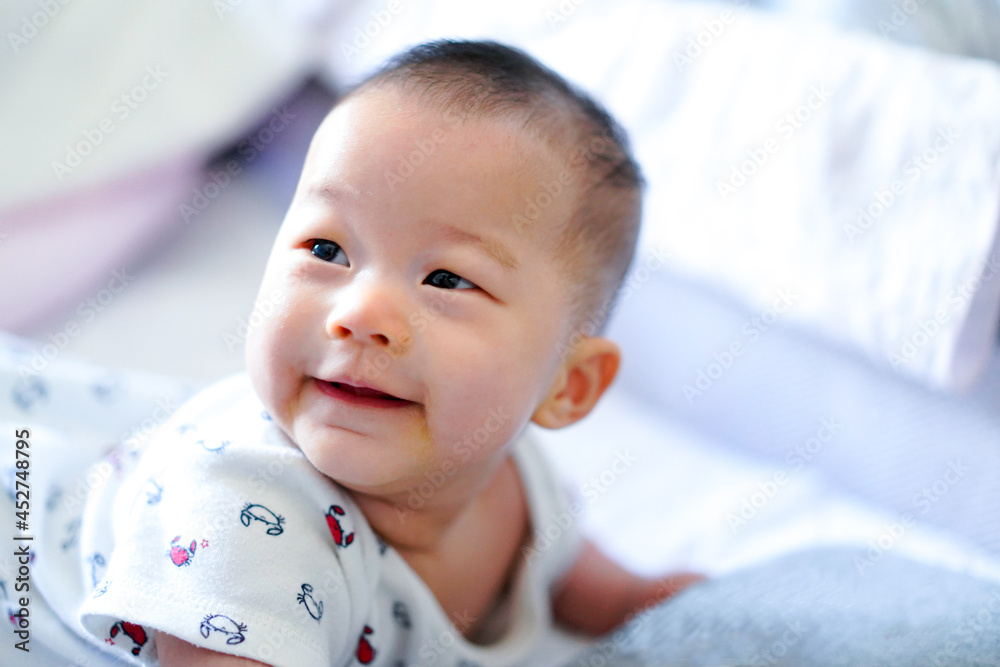 Baby is crawling on bed sheet in her bedroom.Baby smiles and happy in her bedroom with her mother. Baby is crawling on bed sheet in her bedroom.Baby smiles and happy in her bedroom with her mother.