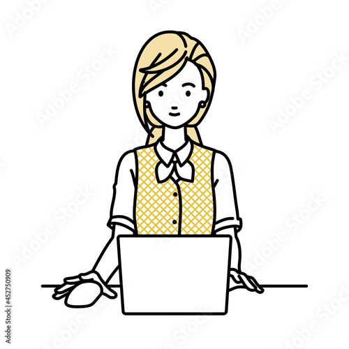 デスクで座ってPCを使っている事務員制服の女性