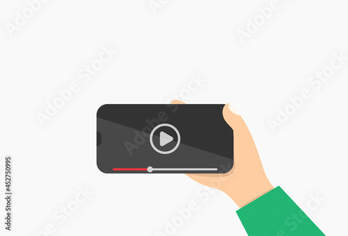 Hand holding smart phone with red video player icon on mobile display, and illustration.