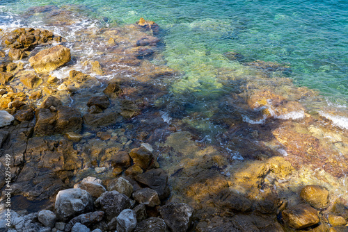 Stones and rocks on the coast of the sea, turquoise water and stony beach, concept of vacation and nature 