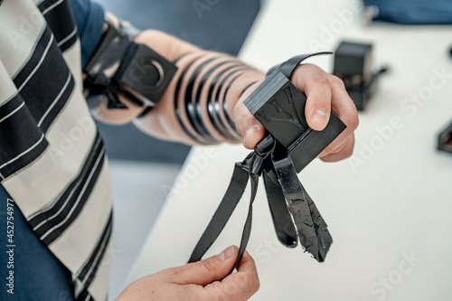 Religious jew, dressed in tallit and with a tefillin on his left hand, holds a tefillin for his head. Jewish religious tradition (1182) photo