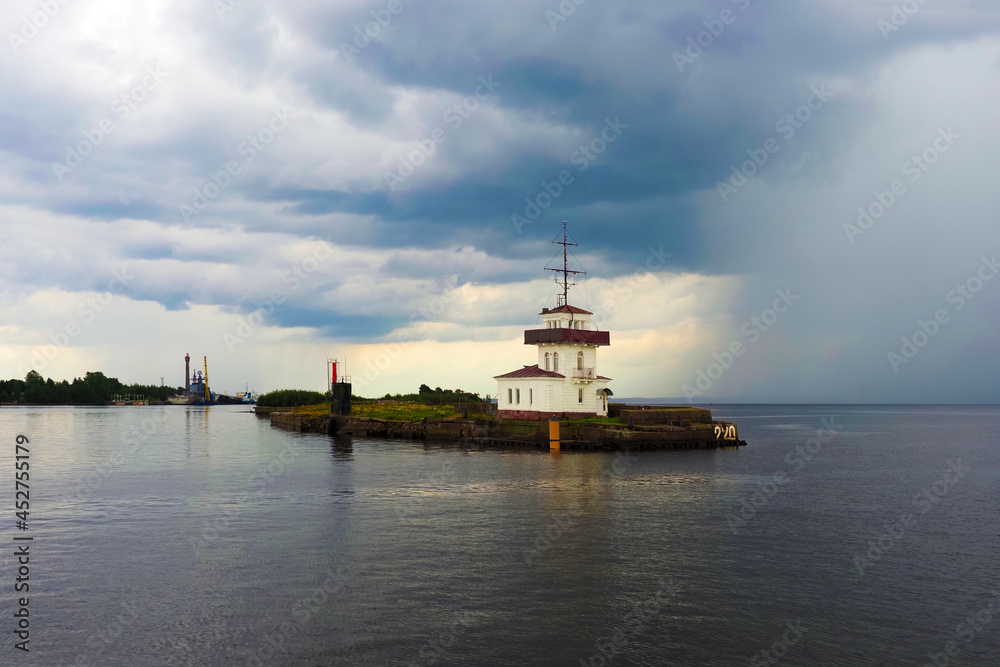 Kronstadt, Saint Petersburg, Russia. Ship traffic service station, which controls the entry and exit of ships from the harbor, storm front in the background