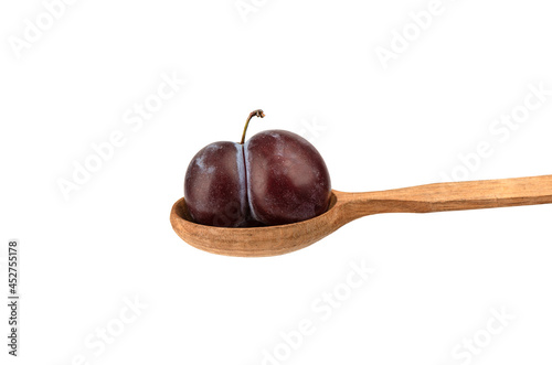 Ripe plum varieties Kabardinka on a wooden spoon isolated on a white background. photo