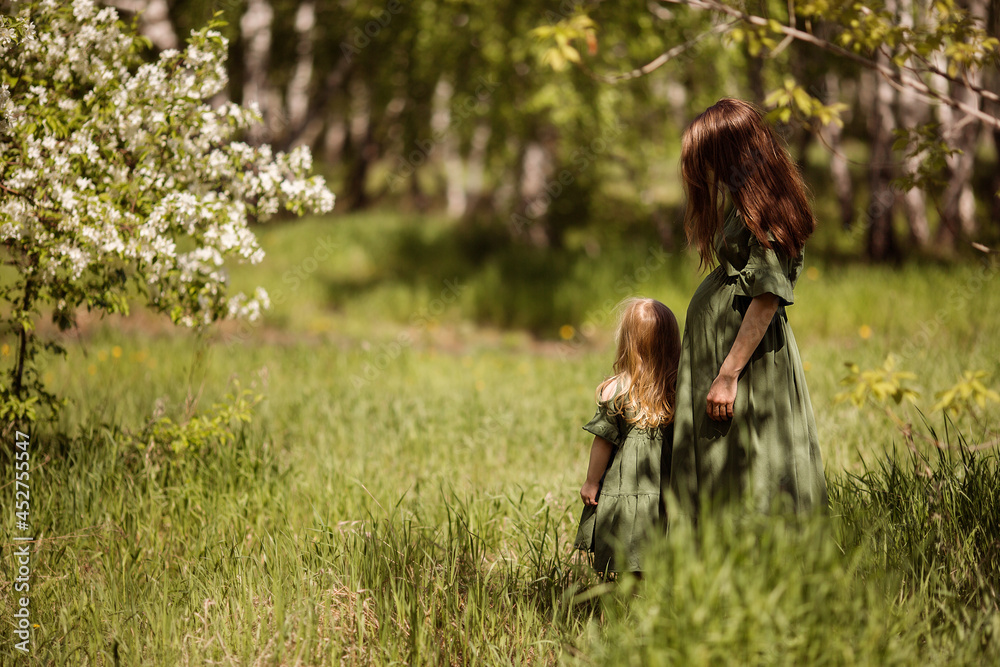 a girl with tall swamp flowers a pregnant woman with a daughter waiting for her second child a girl with tall swamp flowers a pregnant woman with a daughter waiting for her second child