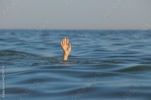 Drowning woman reaching for help in sea © New Africa