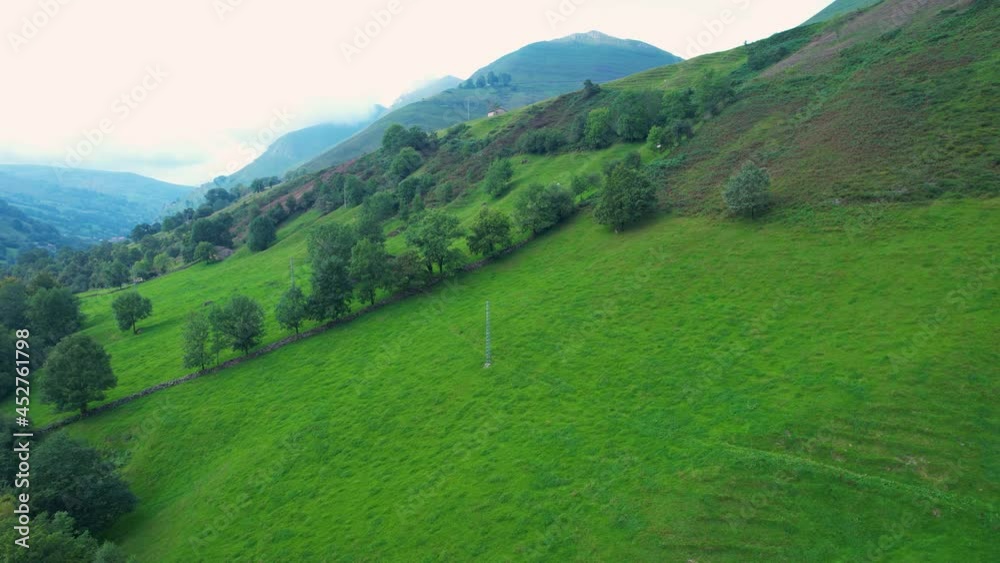 Spring landscape of mowing meadows and cabins in the Miera River Valley. La Concha. Valles Pasiegos, Cantabria, Spain, Europe Spring landscape of mowing meadows and cabins in the Miera River Valley. La Concha. Valles Pasiegos, Cantabria, Spain, Europe
