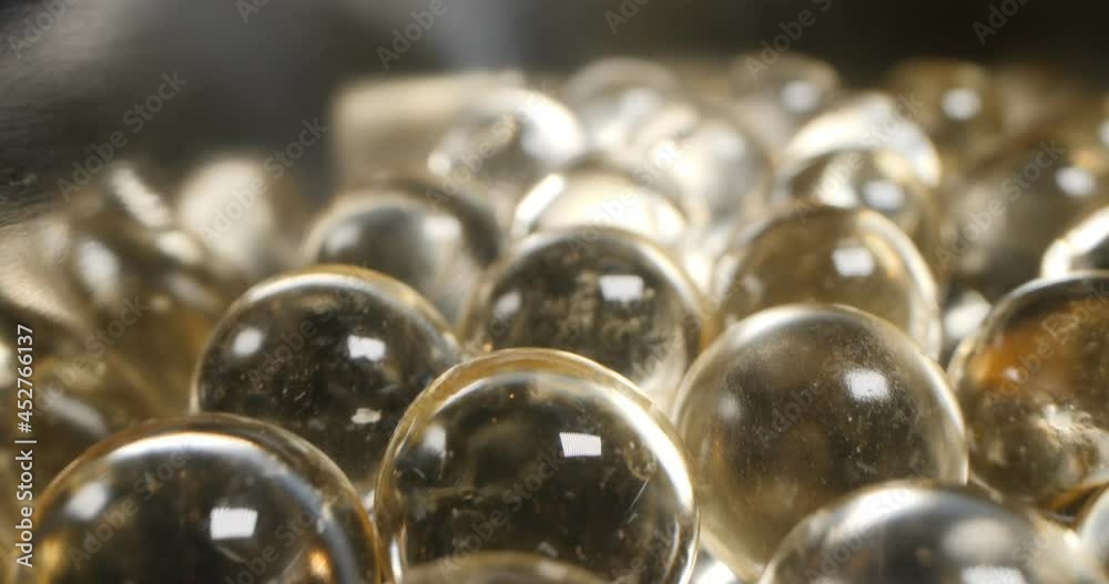 detailed, extreme close-up of round transparent pills. fat-soluble vitamins.