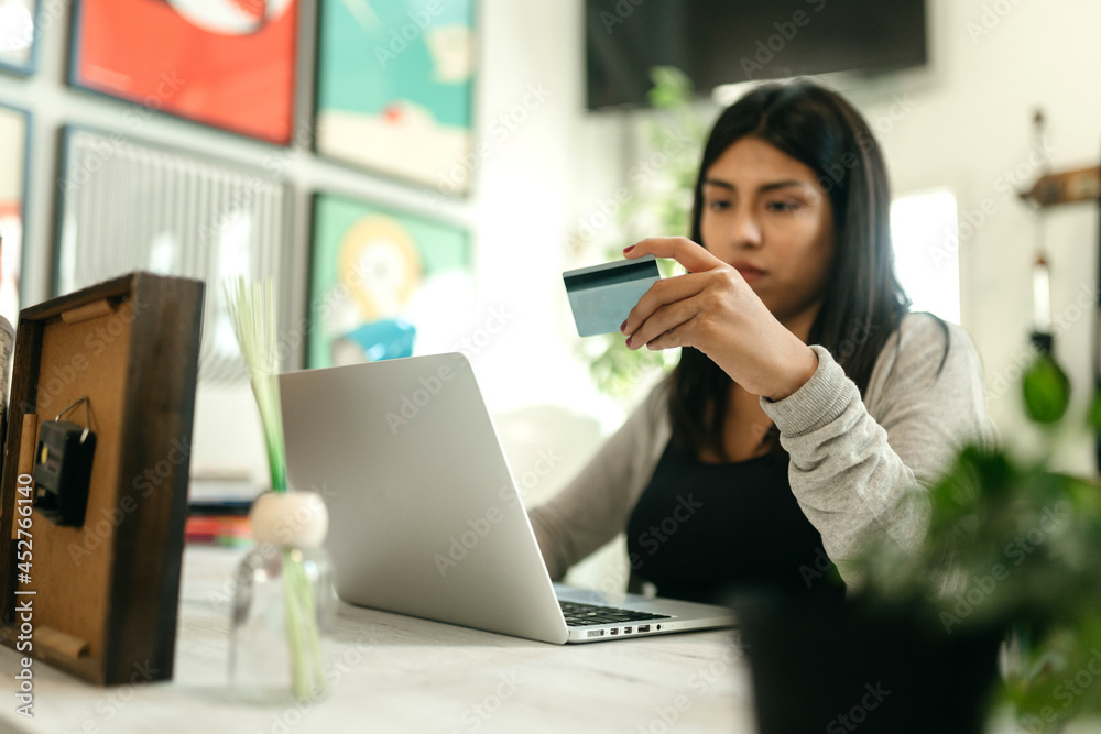 Woman making payment with plastic card during online shopping Woman making payment with plastic card during online shopping