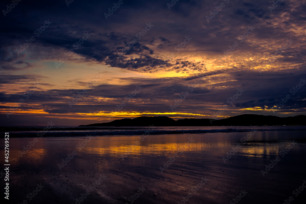 Nascer do sol na praia com nuvens e reflexo no mar - Paisagem natural