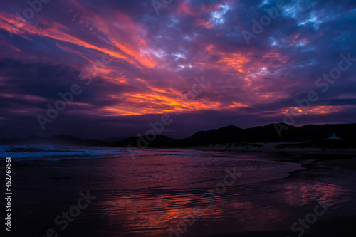 Pôr do sol na praia com nuvens carregadas - Paisagem natural © Dales Hoeckesfeld