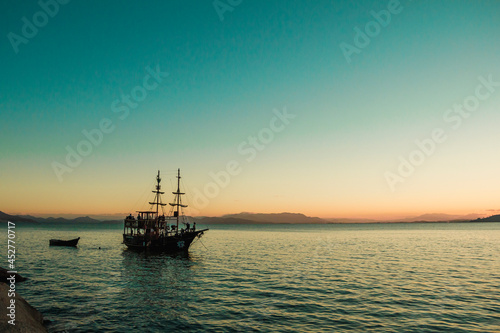 Pôr do sol com barco e vista para o mar em Bombinhas - Santa Catarina - Paisagem natural © Dales Hoeckesfeld