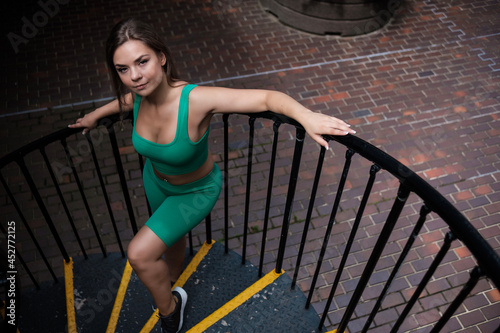 Portrait of young fitness woman posing on stairs.