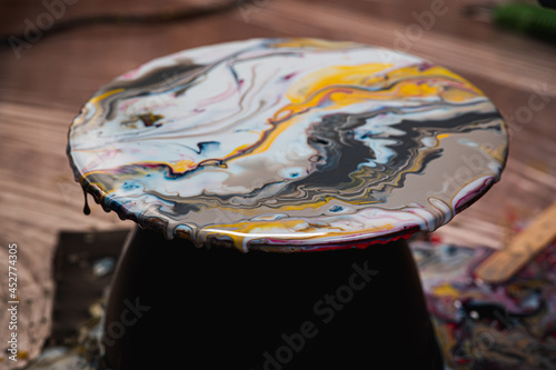 Fluid art on a round canvas. Behind polyethylene. Master class on creating a fluid. The paint drips on the ground.