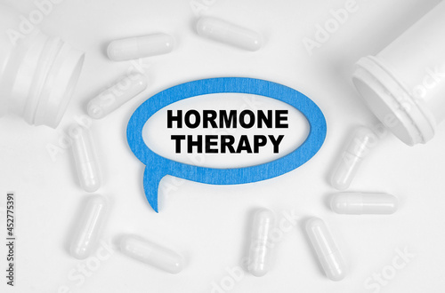 On the table there are pills and a blue plaque inside which the inscription - Hormone Therapy