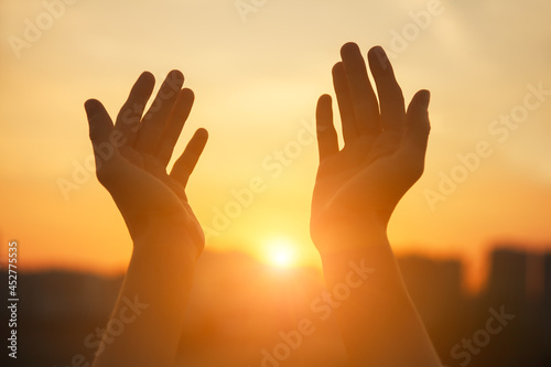 Praying hands at sunset light, spiritual soul, religion concept