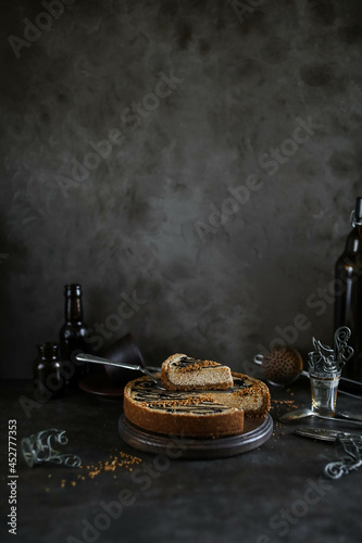 Caramel cake with chocolate icing on a dark table. Food photography in dark style.