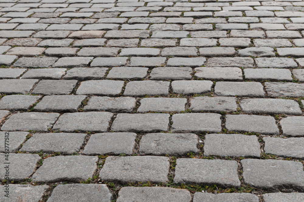 Old cobblestone pavement close-up. Cobblestone sidewalk background. Soft focus